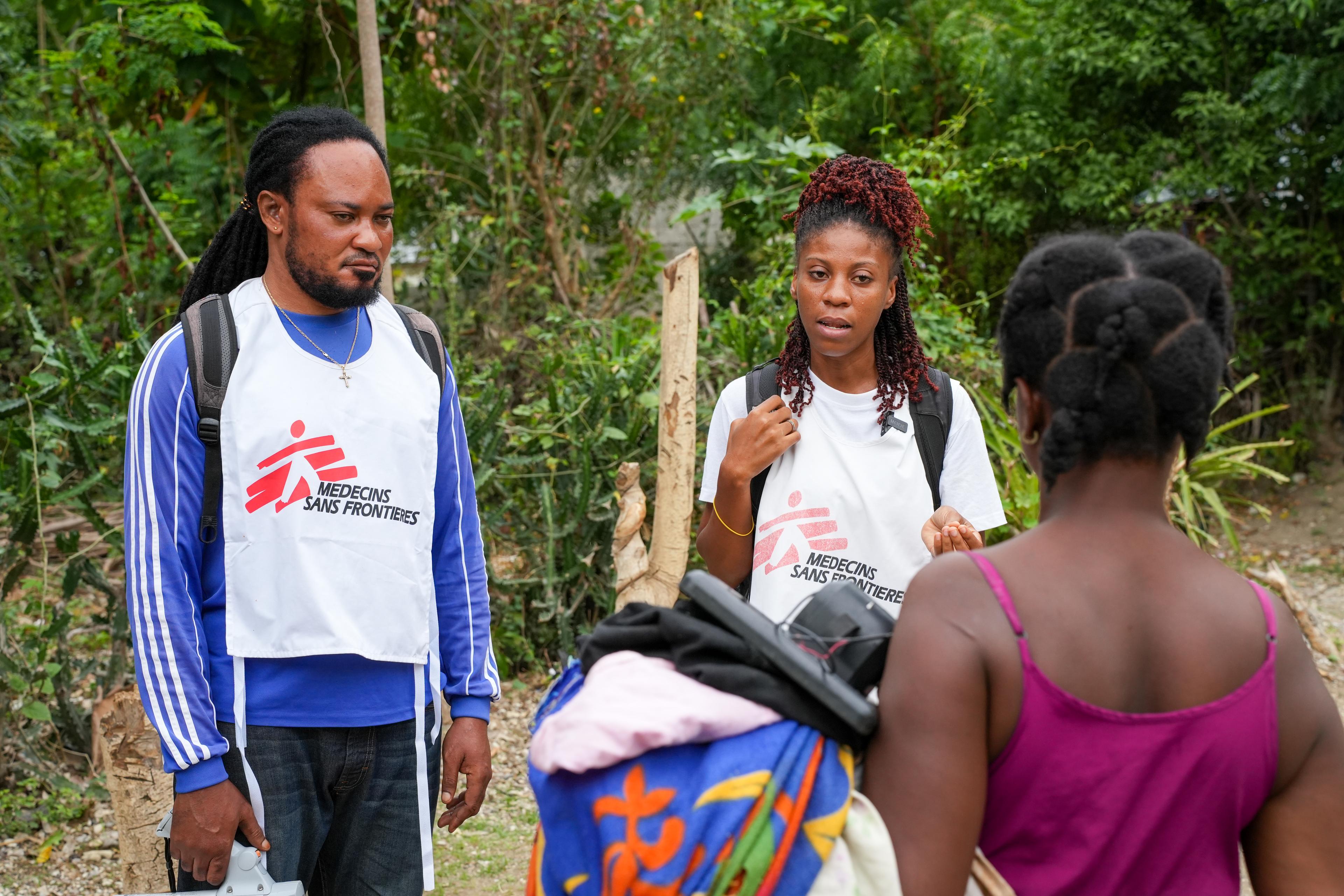 Des promoteurs de santé échangent avec une femme à Calebasse, un village isolé du sud d'Haïti