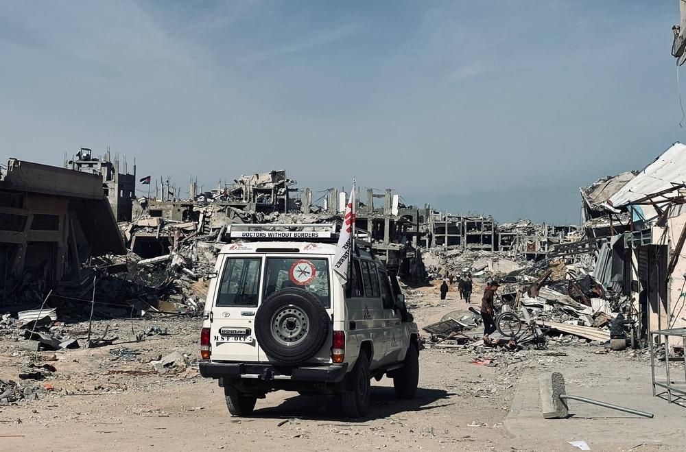 Un véhicule MSF passe devant des bâtiments en ruines à Jabalia, Palestine